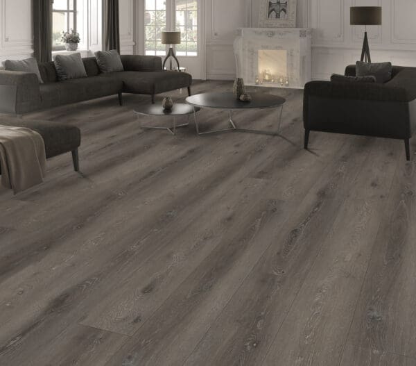 A living room with grey wood floors and furniture.